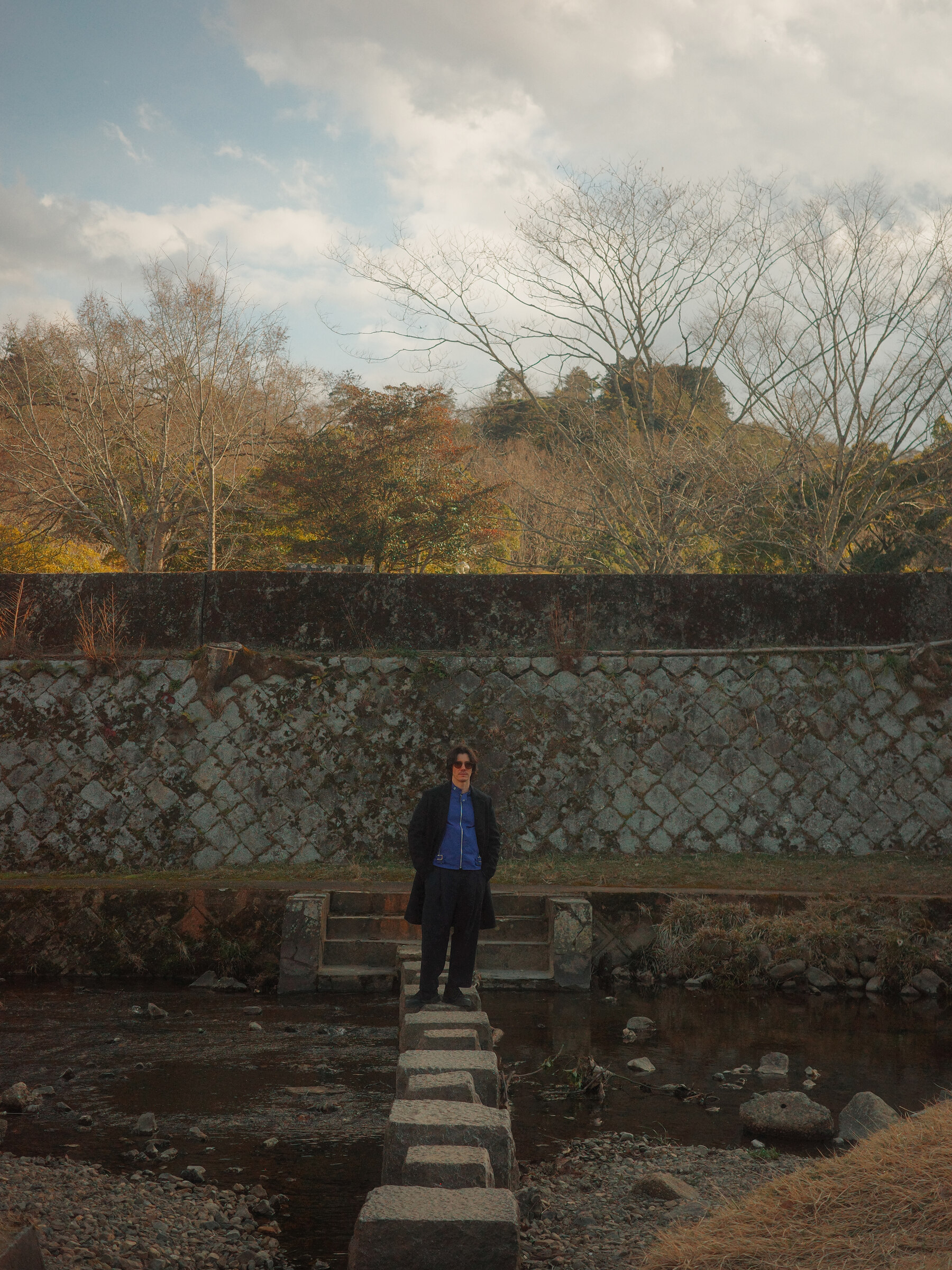 Jorge González Yáñez standing on stepping stones in a landscape